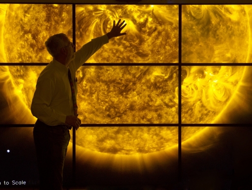 A man touches a visual of the suns surface.