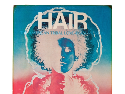 Poster with silhouette in blue and red of man with afro, large type font at top spells hair.