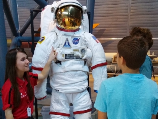 A young woman shares a full-sized astronaut suit