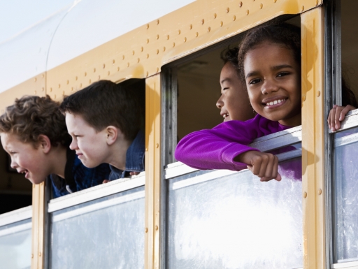 Smiling students in a school bus.