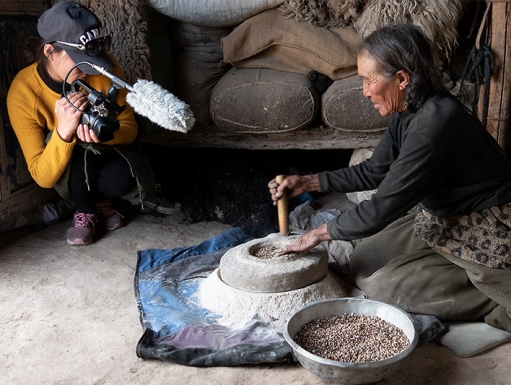 A researcher records a woman creating pottery.